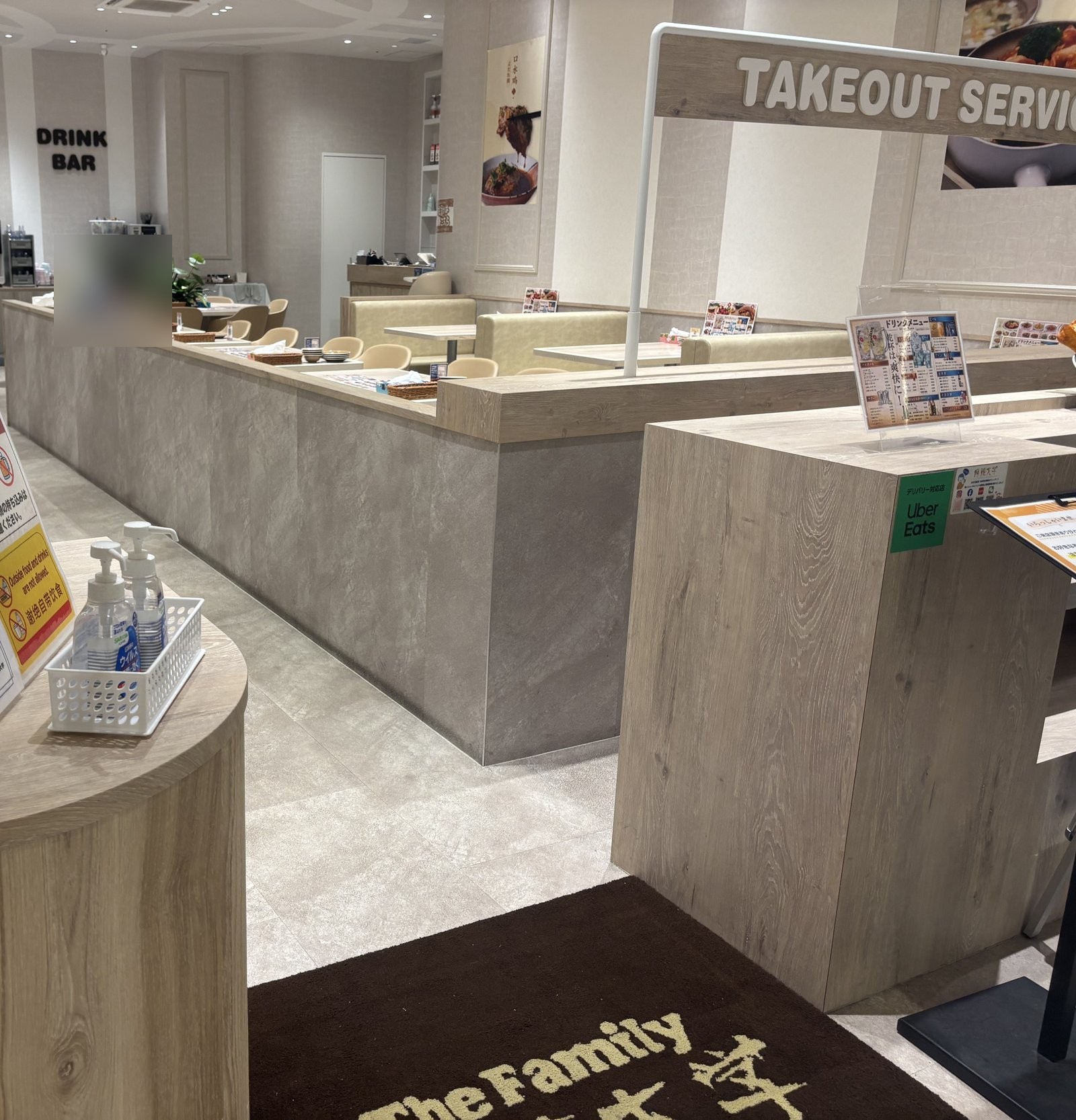 テイクアウトサービスの看板とドリンクバーがある店内